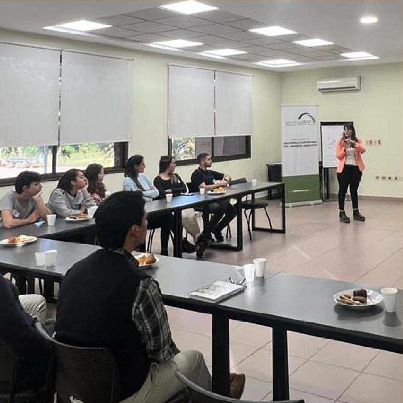 grupo de personas en una sala de conferencias desayunando